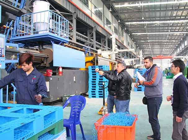 International buyer photographing injection molding equipment during a factory audit